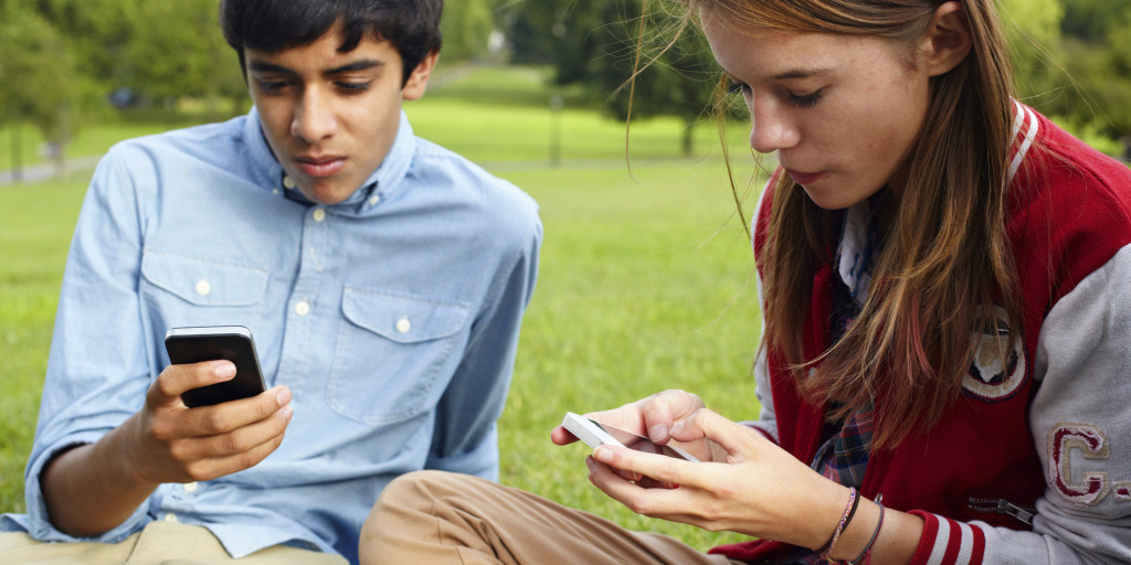 Teenage boy and girl using smartphones